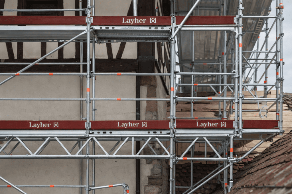Detalle del sistema de andamio multidireccional Layher en una construcción, destacando su estructura modular y flexible para trabajos en altura con seguridad.